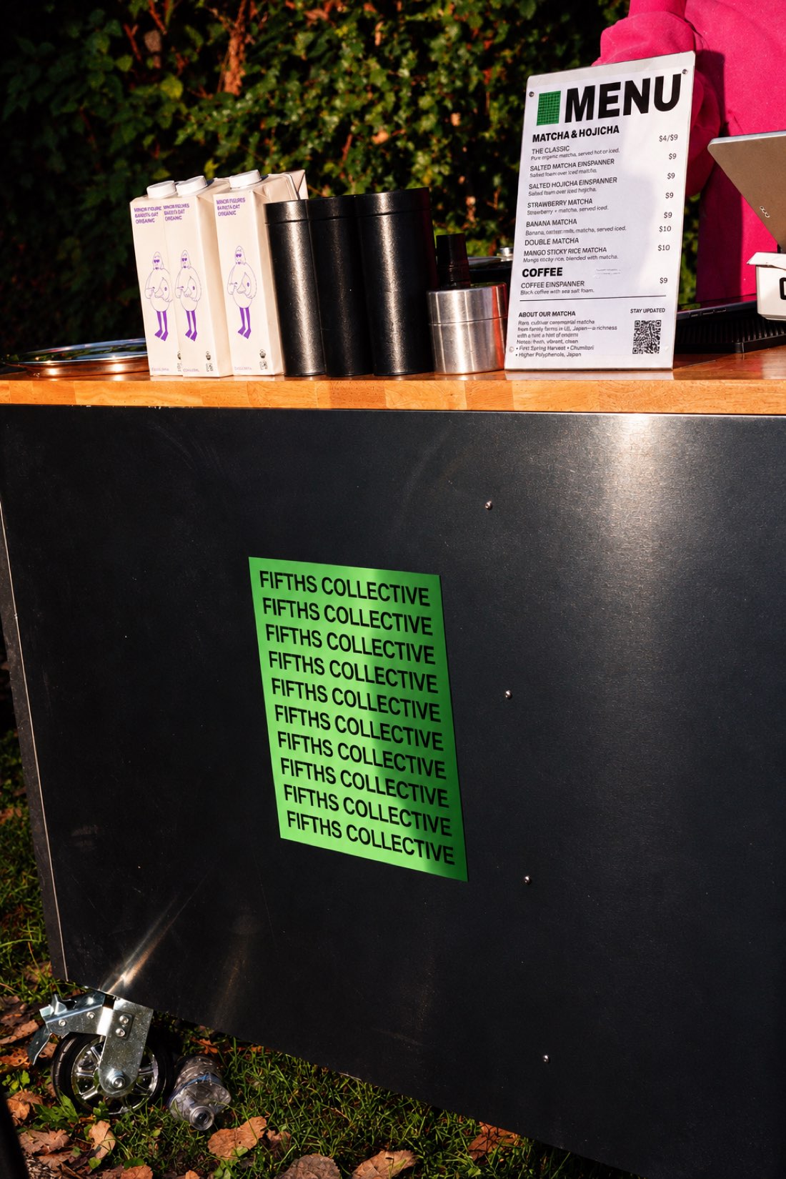 The Fifths Collective cart set up outdoors with its menu board and oat milk on the counter