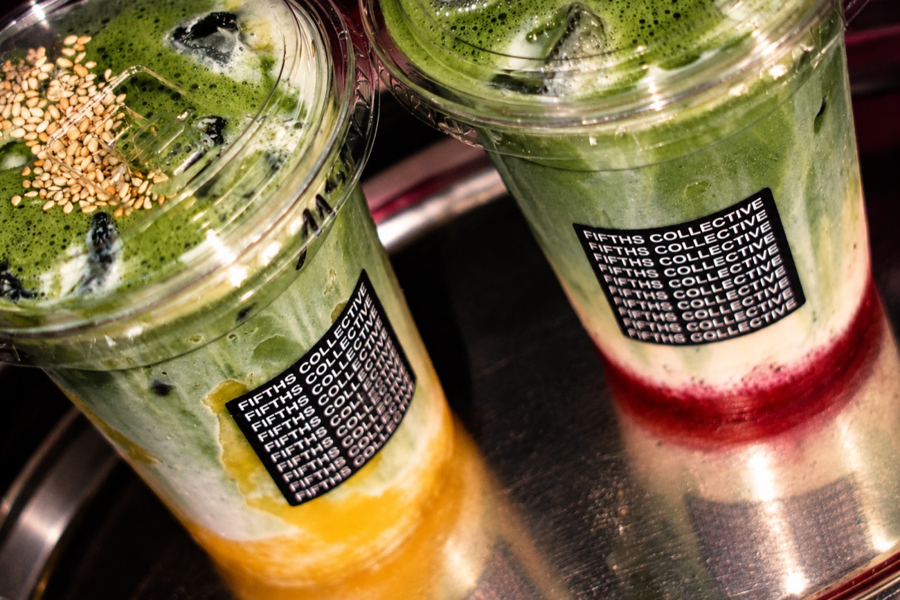 A mango matcha and a strawberry matcha on a steel tray, stickers facing out