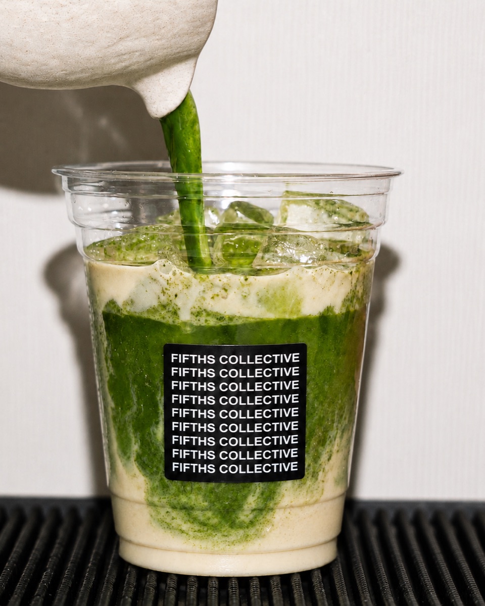Matcha being poured over ice into a Fifths Collective cup