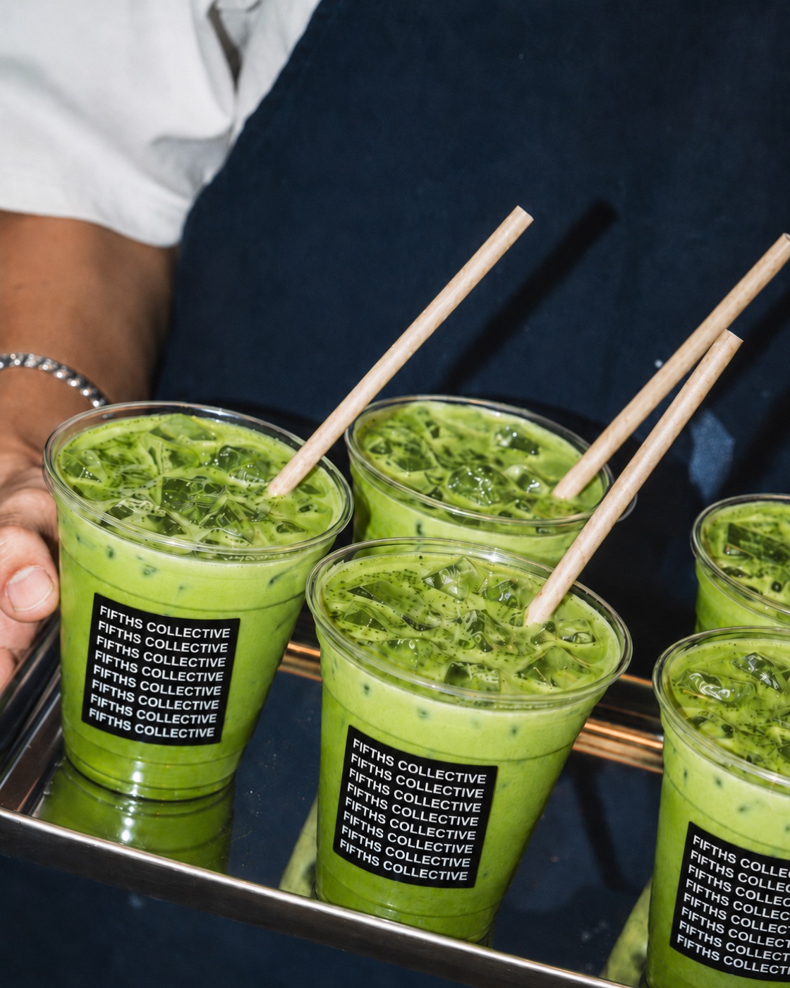 A tray of iced Fifths Collective matcha being carried out at an event